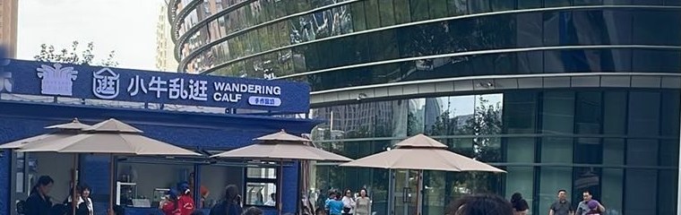 图注：广场东侧的蓝色档口，挡板上方写着"小牛乱逛 WANDERING CALF"。