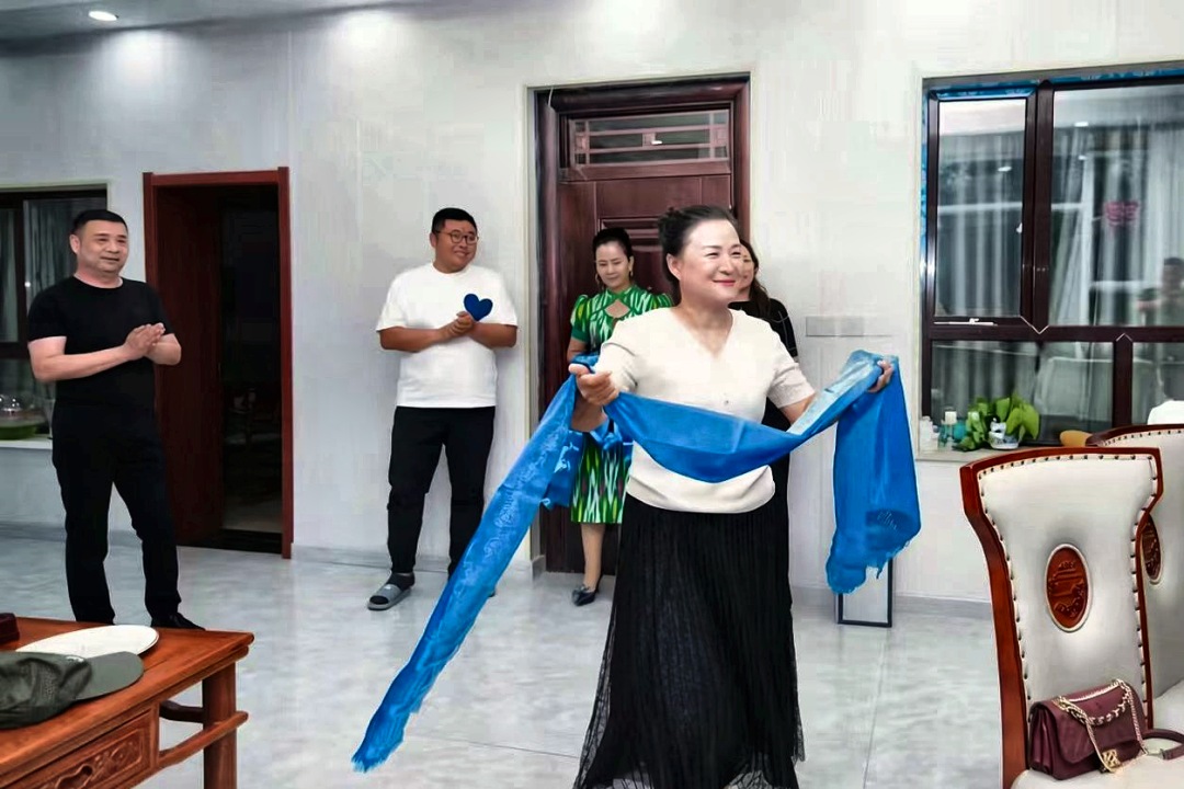 迎宾时，她手捧一条蓝绸。