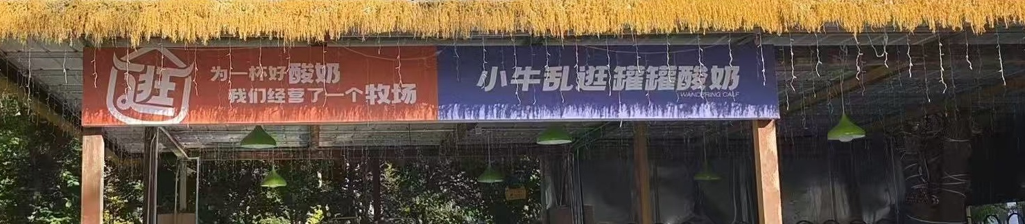 吧台上方的两块牌子：“为了一杯好酸奶，我们经营了一个牧场”“小牛乱逛罐罐酸奶”